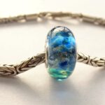 Heldere lampwork glaskraal met blauw reductieglas