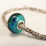 Turquoise blauwe glaskraal met vlekken