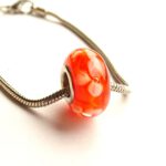 Oranje glaskraal met witte bloemen