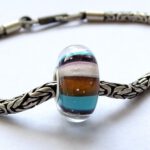 gestreepte glaskraal met blauw en oranje