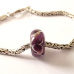 Glasbedel met donkerpaarse bloemen