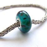 Turquoise glasbedel met onegelmatig patroon