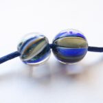 Set van 2 gestreepte glaskralen in blauw met grijs