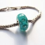 Turquoise glaskraal met luchtbellen in vakje