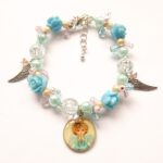 Blauwe kinderarmband met roosjes en engeltje